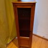 Mueble con repisas de madera y puerta de vidrio