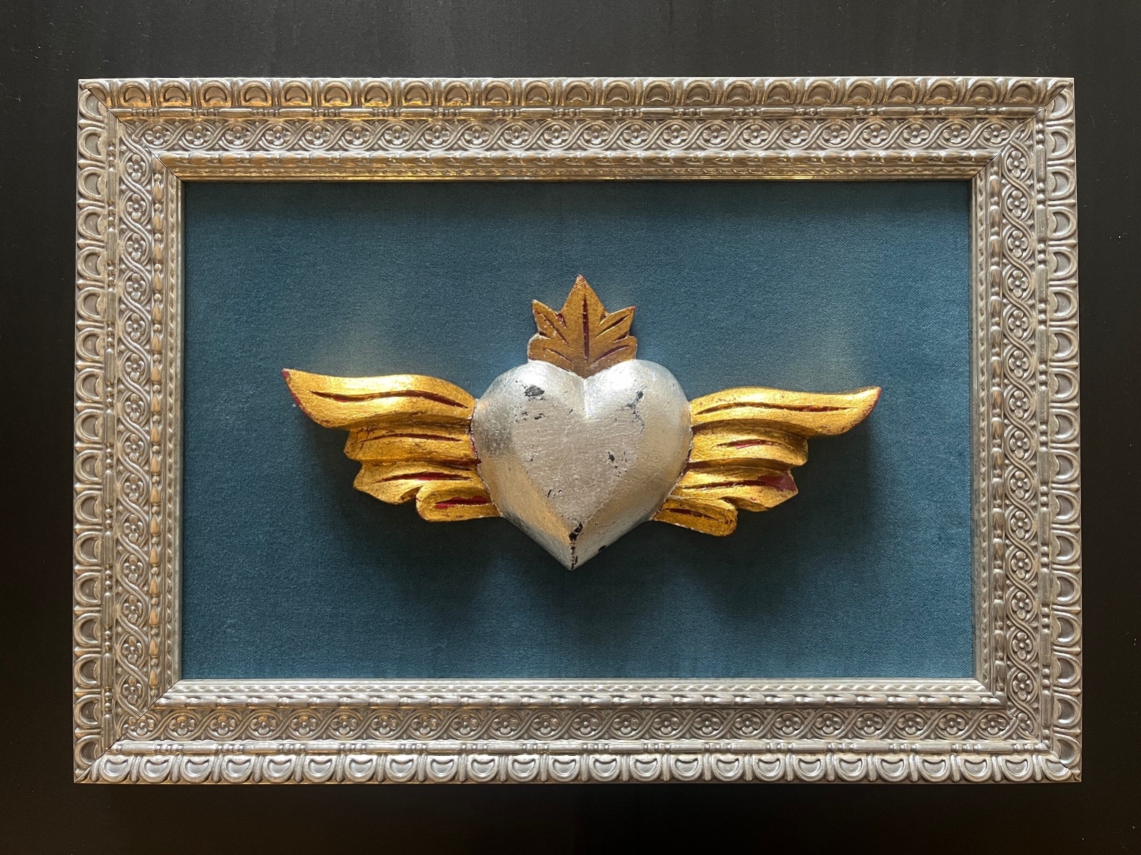 Corazón alado en madera sobre terciopelo celeste