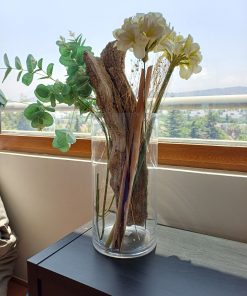Florero vidrio con arreglo flores artificiales y ramas