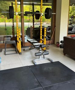 Half rack con pesas, banqueta y colchonetas negras